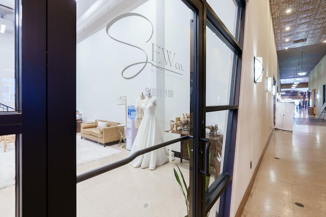 hallway with a towering ceiling and french doors