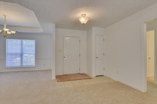 1008 Storey Mill Ct, Hephzibah, GA 30815 - foyer entrance featuring light colored carpet, a chandelier, light tile patterned flooring, a textured ceiling, and wainscoting