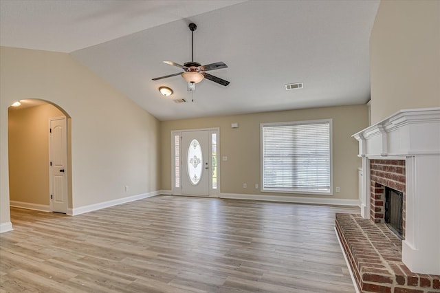 2030 Lake Forest Dr, Grovetown, GA 30813 - unfurnished living room with ceiling fan, vaulted ceiling, a brick fireplace, light wood-style floors, and arched walkways