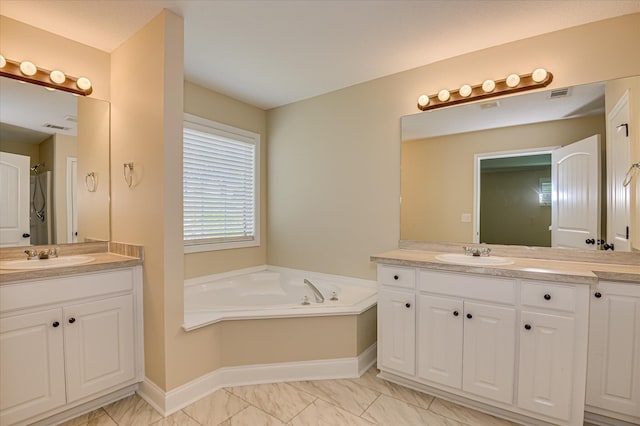 2030 Lake Forest Dr, Grovetown, GA 30813 - bathroom featuring two vanities, a garden tub, and marble look tiles
