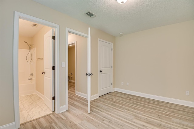 2030 Lake Forest Dr, Grovetown, GA 30813 - unfurnished bedroom with light wood finished floors, a textured ceiling, and ensuite bathroom