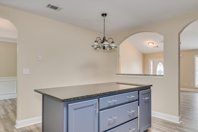 2030 Lake Forest Dr, Grovetown, GA 30813 - kitchen with dark countertops, light wood-type flooring, hanging light fixtures, and blue cabinets