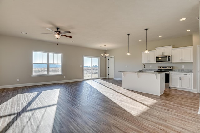 kitchen featuring light wood-style floors, a breakfast bar area, stainless steel appliances, and open floor plan