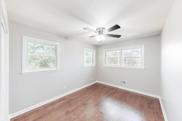 empty room with ceiling fan and dark wood-type flooring