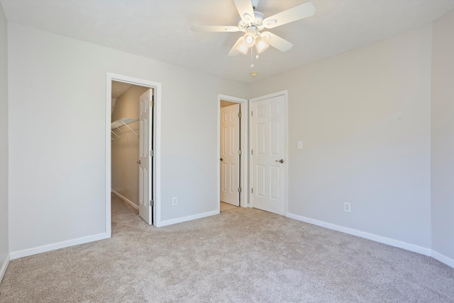 unfurnished bedroom with carpet flooring, baseboards, a closet, and a spacious closet