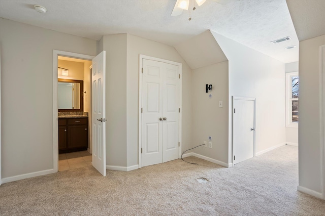 unfurnished bedroom with a textured ceiling, baseboards, visible vents, and light carpet