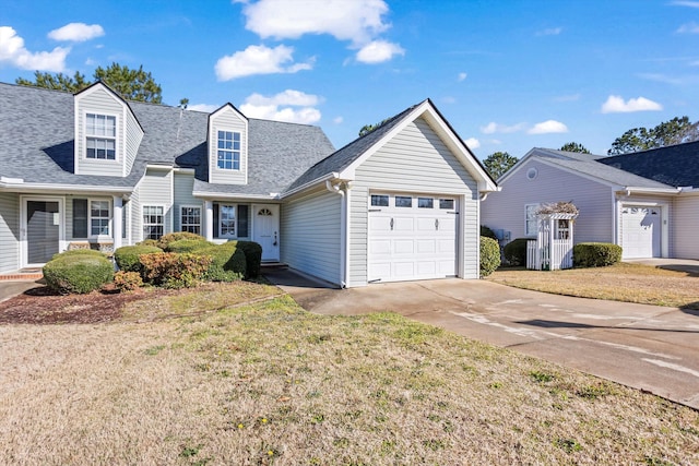 view of front of property featuring a front yard, concrete driveway, an attached garage, and a shingled roof