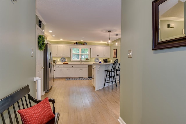 138 Evergreen Ln, Mccormick, SC 29835 - kitchen featuring stainless steel appliances, a breakfast bar, white cabinetry, a sink, and light wood finished floors