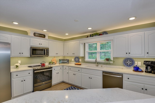 138 Evergreen Ln, Mccormick, SC 29835 - kitchen with stainless steel appliances, a sink, white cabinets, light stone countertops, and recessed lighting