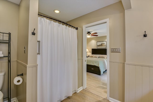 138 Evergreen Ln, Mccormick, SC 29835 - ensuite bathroom with toilet, wood finished floors, a shower with curtain, ceiling fan, and wainscoting