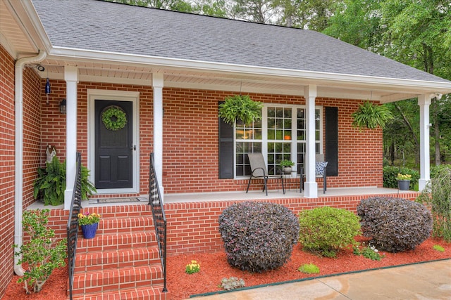 138 Evergreen Ln, Mccormick, SC 29835 - view of exterior entry with covered porch, brick siding, and a shingled roof