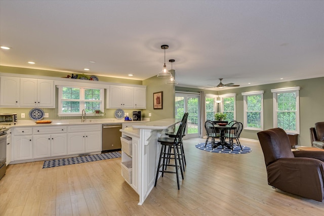 138 Evergreen Ln, Mccormick, SC 29835 - kitchen featuring stainless steel dishwasher, a sink, open floor plan, a breakfast bar, and white cabinets