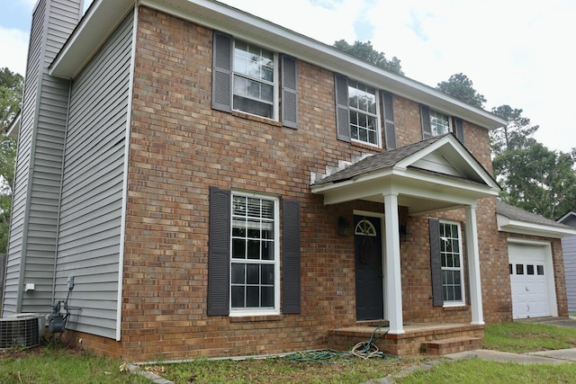 view of front of property featuring brick siding, cooling unit, a chimney, and a garage