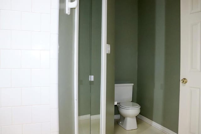 bathroom with baseboards and toilet