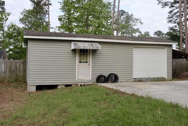 view of outdoor structure featuring fence and driveway