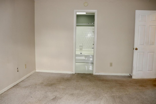unfurnished bedroom with baseboards, carpet, and ensuite bathroom