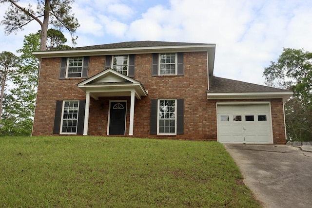 colonial house with an attached garage, concrete driveway, brick siding, and a front yard