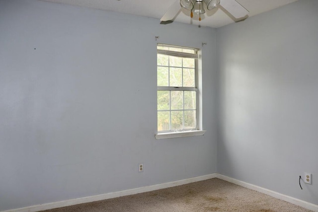 empty room featuring carpet floors, plenty of natural light, baseboards, and a ceiling fan