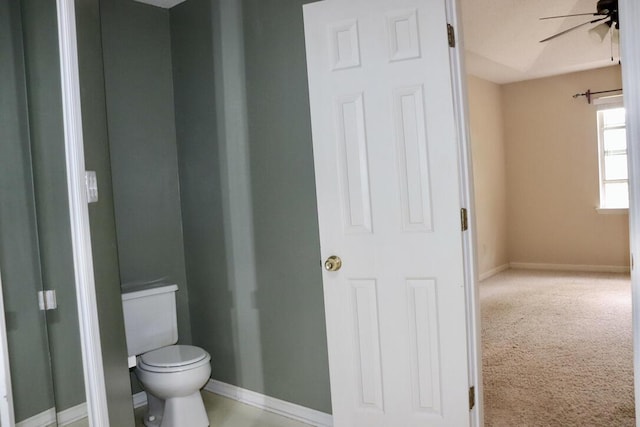 bathroom with toilet, ceiling fan, and baseboards