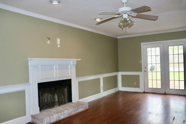 unfurnished living room featuring a brick fireplace, a ceiling fan, ornamental molding, and wood finished floors