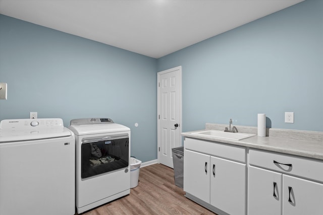 3604 Hillman Gay Rd, Dearing, GA 30808 - laundry area featuring independent washer and dryer, cabinet space, light wood-style flooring, and baseboards