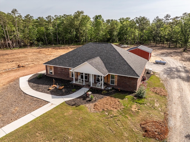 3604 Hillman Gay Rd, Dearing, GA 30808 - view of front facade with covered porch, brick siding, roof with shingles, a front lawn, and dirt driveway
