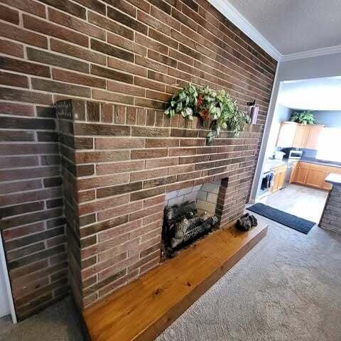 room details featuring carpet floors, a brick fireplace, and ornamental molding