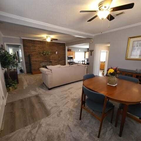 dining area featuring wood finished floors, ceiling fan, and crown molding