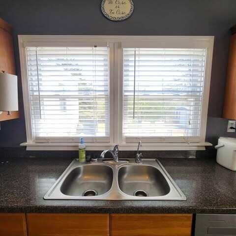 interior details with a sink, dark countertops, and brown cabinetry