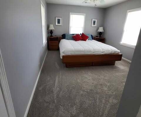 bedroom featuring light carpet and baseboards