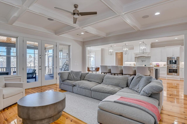 living area featuring light wood finished floors, french doors, and coffered ceiling