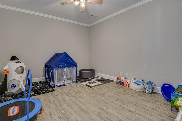 playroom featuring ornamental molding, wood finished floors, visible vents, and baseboards