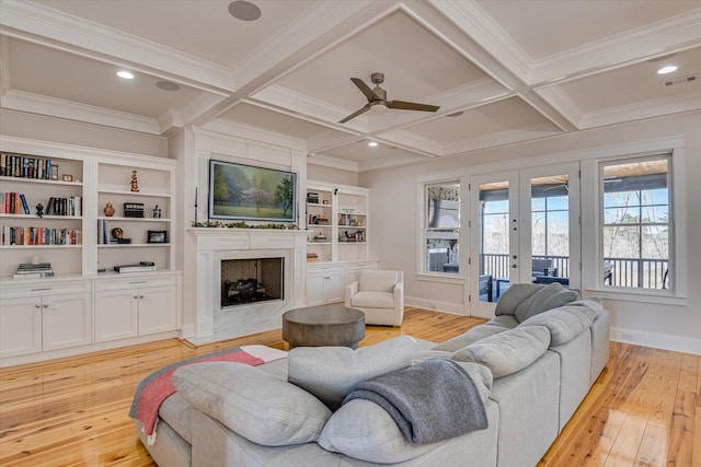 living area featuring a high end fireplace, visible vents, coffered ceiling, and french doors