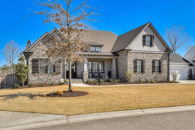 view of front of property with stone siding, metal roof, a standing seam roof, covered porch, and a front lawn