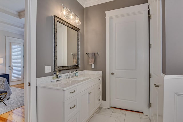 bathroom with marble finish floor, ornamental molding, and vanity