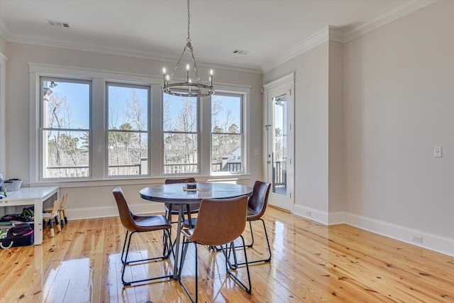 dining space featuring baseboards, ornamental molding, visible vents, and light wood-style floors