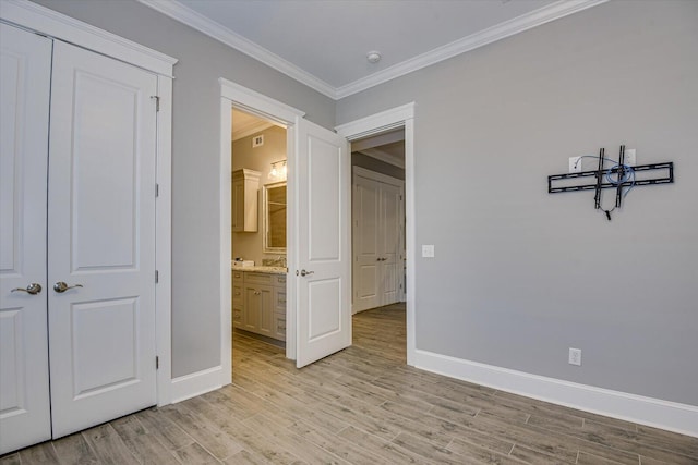 unfurnished bedroom with baseboards, light wood finished floors, a closet, and crown molding