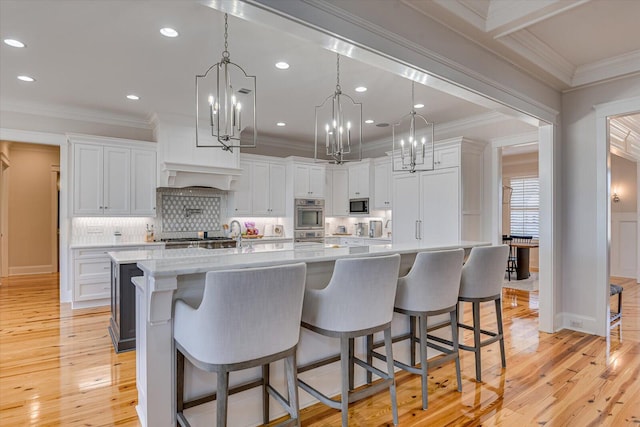 kitchen with ornamental molding, white cabinetry, and built in microwave