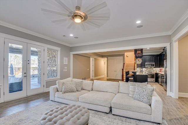 living area featuring french doors, light wood-style flooring, and crown molding