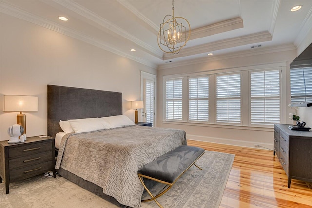 bedroom with ornamental molding, a raised ceiling, a notable chandelier, and light wood-style flooring