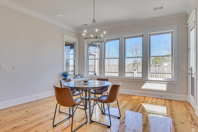 dining room with light wood-type flooring, visible vents, and crown molding