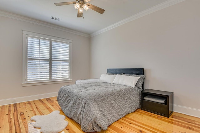 bedroom featuring baseboards, visible vents, ceiling fan, wood finished floors, and crown molding