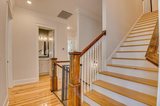 staircase featuring baseboards, visible vents, ornamental molding, wood finished floors, and recessed lighting