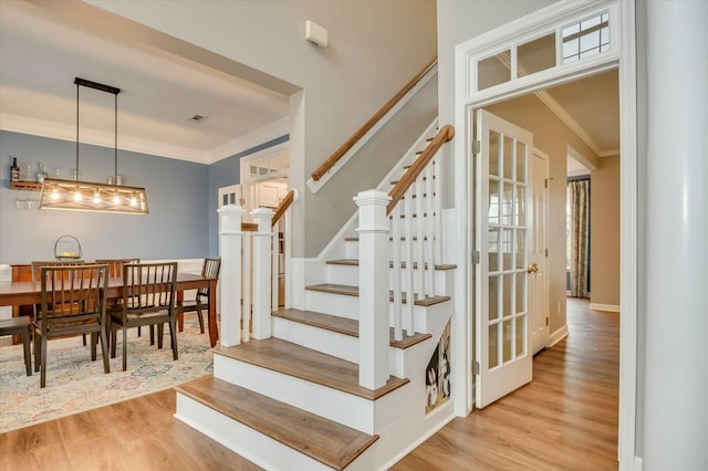 staircase featuring hardwood / wood-style flooring and ornamental molding