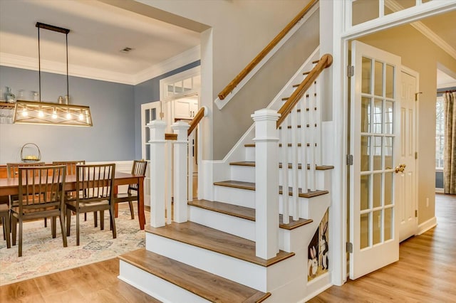 stairway featuring wood-type flooring and ornamental molding