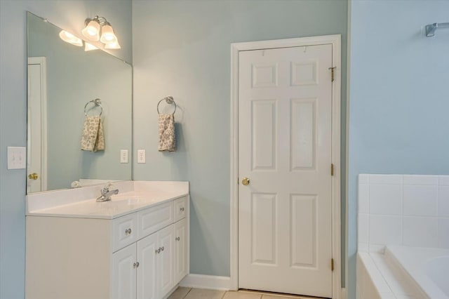 bathroom featuring tile patterned flooring, vanity, and tiled tub