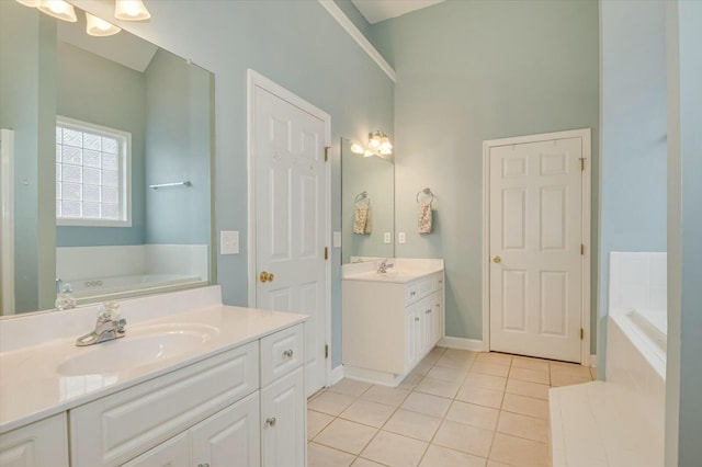 bathroom with vanity, tiled bath, and tile patterned flooring