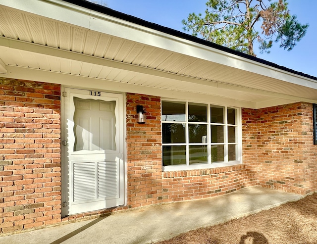 entrance to property featuring brick siding