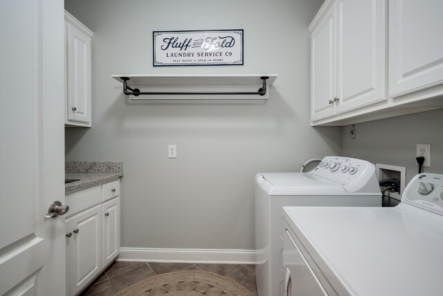 clothes washing area featuring dark tile patterned flooring, cabinets, and independent washer and dryer