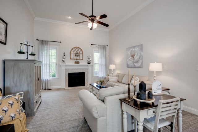 living room featuring ceiling fan, crown molding, a fireplace, and light carpet